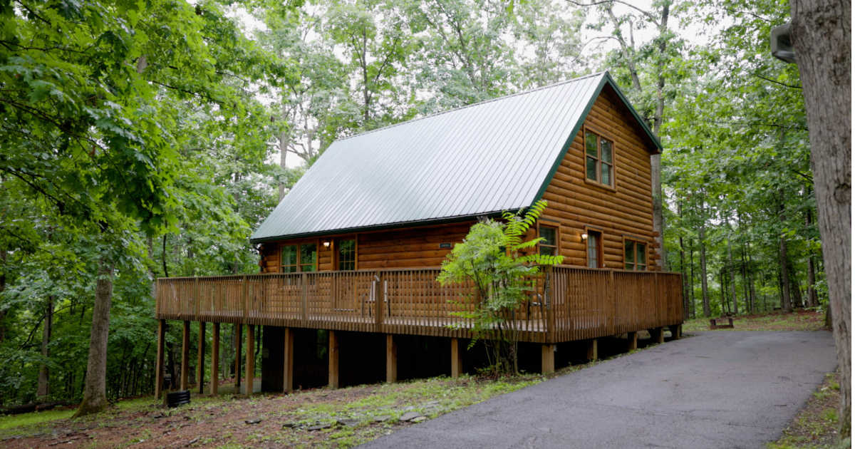 Stay in a rustic log cabin with wrap around porch at Ridge Rider Campground.